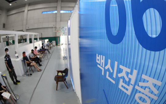 20일 오전 서울 동작구 제2예방접종센터가 마련된 동작구민체육센터에서 시민들이 백신 접종을 기다리고 있다. 정부는 이날 확산세가 지속됨에 따라 현행 '사회적 거리두기'(수도권 4단계, 비수도권 3단계)와 사적모임 인원제한 조치를 내달 5일까지 2주 연장하기로 했다. <연합뉴스>